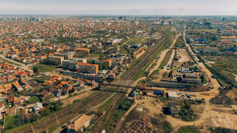 Aerial view of a town with multiple rail lines crossing a central area, bordered by residential blocks and roads.